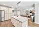Bright open kitchen features a center island, stainless appliances, and flows into the living room at 1500 Highland Farm Dr, Suwanee, GA 30024