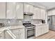 A kitchen with white cabinetry, mosaic backsplash, stainless steel appliances, and granite countertops at 1500 Highland Farm Dr, Suwanee, GA 30024