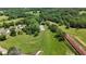 Beautiful aerial view showcasing vast green land with a riding arena and barn at 200 Mcclure Dr, Cumming, GA 30028