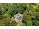 Aerial shot of the home surrounded by dense trees, with a parking area and blue canopies at 200 Mcclure Dr, Cumming, GA 30028