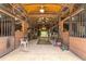 Interior of a horse barn with stalls and open passageway that leads out to a sunlit grassy area at 200 Mcclure Dr, Cumming, GA 30028