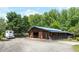 Exterior of a large barn with a blue roof, open doors, trailer parking, and a gravel driveway at 200 Mcclure Dr, Cumming, GA 30028