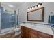 This bathroom boasts blue tiled shower and a wood vanity at 200 Mcclure Dr, Cumming, GA 30028