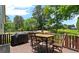 Wooden deck with metal patio furniture, a grill, and wooded back yard views at 200 Mcclure Dr, Cumming, GA 30028