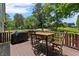 Outdoor deck features a dining set, grill, and a lovely view of the serene backyard at 200 Mcclure Dr, Cumming, GA 30028