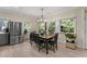 Dining area with modern light fixture, stainless fridge, and large windows with scenic outdoor views at 200 Mcclure Dr, Cumming, GA 30028