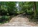 Picturesque tree-lined driveway featuring a wooden bridge and fencing leads to the property at 200 Mcclure Dr, Cumming, GA 30028