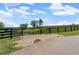Gated driveway leading to a property with green pasture and perimeter fencing at 200 Mcclure Dr, Cumming, GA 30028
