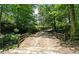 A private drive leading to the property, framed by a wooden fence and natural green surroundings at 200 Mcclure Dr, Cumming, GA 30028