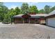 Charming home with a covered porch, stone accents, and a detached two-car garage with ample parking space at 200 Mcclure Dr, Cumming, GA 30028