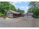 Charming home with a covered porch, stone accents, and a detached two-car garage with ample parking space at 200 Mcclure Dr, Cumming, GA 30028