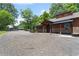 Charming home with a covered porch, stone accents, and a detached two-car garage with ample parking space at 200 Mcclure Dr, Cumming, GA 30028