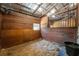 Horse stall with wood-panel walls, a window, a fan, and a bucket in the corner at 200 Mcclure Dr, Cumming, GA 30028