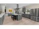 Open-concept kitchen features gray cabinets, stainless steel appliances, and a center island with seating at 200 Mcclure Dr, Cumming, GA 30028