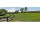 Scenic grassy field with mature trees and wooden fencing at 200 Mcclure Dr, Cumming, GA 30028