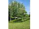 Expansive green land with lush grass and mature trees, enclosed by charming wooden fencing at 200 Mcclure Dr, Cumming, GA 30028