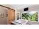 The soaking tub features a beautiful wooded view and has a sliding barn door for privacy at 200 Mcclure Dr, Cumming, GA 30028