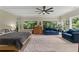 The main bedroom features hardwood floors, a ceiling fan, seating, and several windows with tree and sky views at 200 Mcclure Dr, Cumming, GA 30028