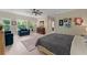 A spacious main bedroom features light hardwood floors, art, ceiling fan and dual arm chairs at 200 Mcclure Dr, Cumming, GA 30028