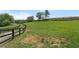 Expansive green pasture with black fencing and mature trees in the background at 200 Mcclure Dr, Cumming, GA 30028