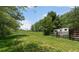 Image of a lush green pasture with mature trees and a horse trailer parked beside a split rail fence at 200 Mcclure Dr, Cumming, GA 30028