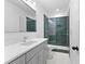Bathroom with green shower, glass doors, and gray vanity with white countertop at 208 Regester Way, Peachtree City, GA 30269