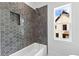 Updated bath and shower with hexagon tiling, shower niche, and neighborhood views at 208 Regester Way, Peachtree City, GA 30269