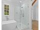 Modern bathroom showcasing a glass-enclosed shower and soaking tub with natural light at 208 Regester Way, Peachtree City, GA 30269