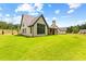 A beautiful exterior of a home with vertical siding, dark trim, and a sprawling green lawn at 208 Regester Way, Peachtree City, GA 30269