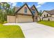 Beautiful home exterior features a multi-car garage, stone accents, and a well-manicured lawn at 208 Regester Way, Peachtree City, GA 30269