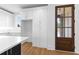 Bright kitchen with white cabinets, pantry, quartz counters, hardwood floors and a wood door at 208 Regester Way, Peachtree City, GA 30269