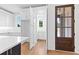 Bright kitchen with white cabinets, open pantry, quartz counters, hardwood floors and a wood door at 208 Regester Way, Peachtree City, GA 30269