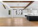 Open-concept living room with island kitchen, hardwood floors, wood beams, and abundant natural light at 208 Regester Way, Peachtree City, GA 30269