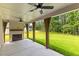 Covered patio has an outdoor fireplace, ceiling fans, and scenic backyard views at 208 Regester Way, Peachtree City, GA 30269