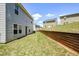 A well-maintained backyard with lush green grass and a sturdy wooden retaining wall for landscaping at 354 Jada Ln, Villa Rica, GA 30180
