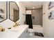 Bathroom featuring double sinks, black accents, a decorative mirror, and patterned tile at 354 Jada Ln, Villa Rica, GA 30180