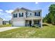 Inviting two-story home with a manicured lawn, integrated garage, and covered porch perfect for relaxing at 354 Jada Ln, Villa Rica, GA 30180
