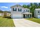 Two-story home featuring a two car garage, covered front porch, and an adjacent home on each side at 354 Jada Ln, Villa Rica, GA 30180