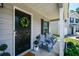 Inviting covered porch with seating, a decorative wreath, and a neatly landscaped garden area at 354 Jada Ln, Villa Rica, GA 30180