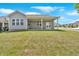 A view of the home's backyard featuring green grass and a covered patio area with windows and a double door at 427 Bluffs View Ln, Canton, GA 30114
