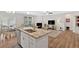 Open kitchen with a large island, seating, stainless appliances, and a clear view to the fireplace and living room at 427 Bluffs View Ln, Canton, GA 30114