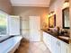 Elegant bathroom featuring dual sinks, marble countertops, and a freestanding soaking tub at 1739 Praters Pt, Dacula, GA 30019