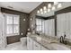 Bathroom featuring dual sinks, granite countertops, shuttered windows, and a shower/tub combo at 1739 Praters Pt, Dacula, GA 30019