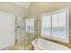 Elegant bathroom featuring a glass-enclosed shower and a freestanding soaking tub at 1739 Praters Pt, Dacula, GA 30019