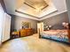 Spacious bedroom featuring a tray ceiling with fan and natural wood furniture set at 1739 Praters Pt, Dacula, GA 30019