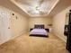 Spacious bedroom with a tray ceiling, ceiling fan, and neutral carpeting at 1739 Praters Pt, Dacula, GA 30019