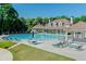 Community pool with lounge chairs, tables, umbrellas and a covered seating area for relaxation at 1739 Praters Pt, Dacula, GA 30019