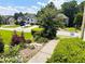 Landscaped front yard featuring lush greenery, stone steps, and views of neighboring homes across street at 1739 Praters Pt, Dacula, GA 30019