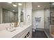 Sleek bathroom with double sinks, modern fixtures, a glass-enclosed shower, and gray tiling at 1820 Peachtree St # 311, Atlanta, GA 30309