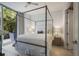 Bright bedroom with a canopy bed, hardwood floors, and a view of greenery from the large windows at 1820 Peachtree St # 311, Atlanta, GA 30309